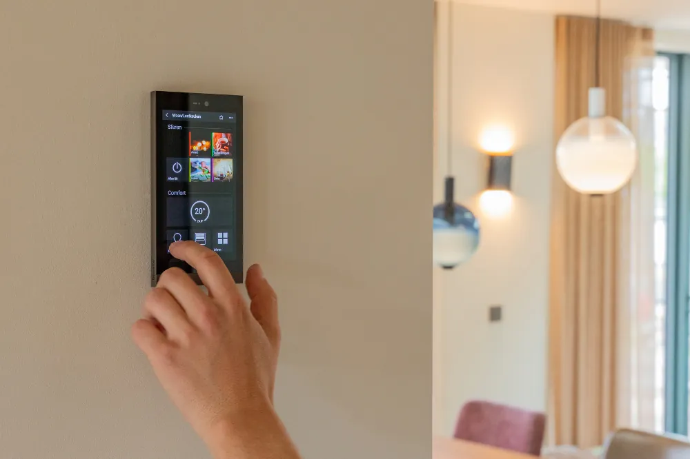 Hand bedient een Basalte Ellie touchscreen met menu-opties voor sferen en comfort.